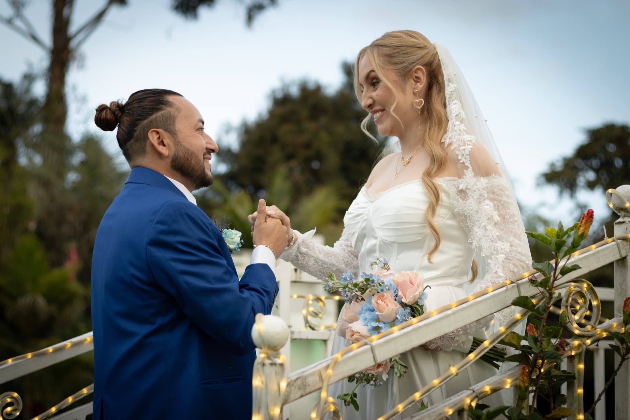 Pareja de novios mirándose con complicidad al aire libre