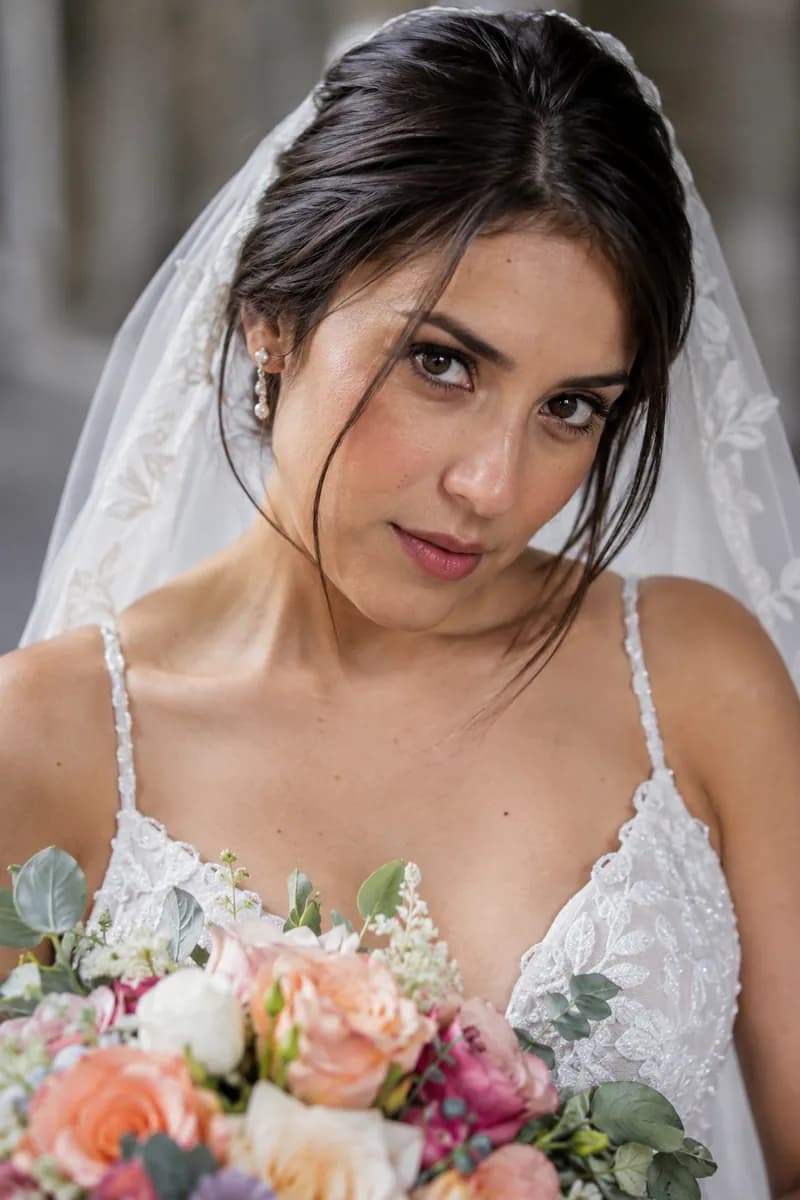 Ilustración creada con IA: retrato de novia con ramo abajo, cabeza inclinada, mentón bajo y sonrisa cerrada