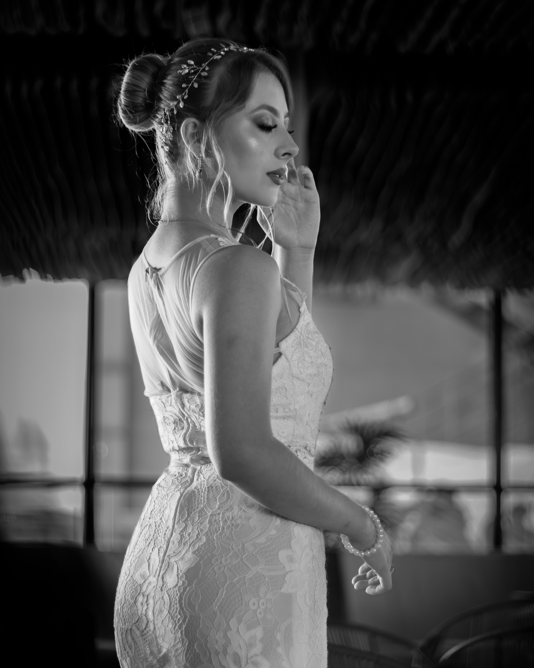 Novia de perfil en blanco y negro con la mano cerca del rostro