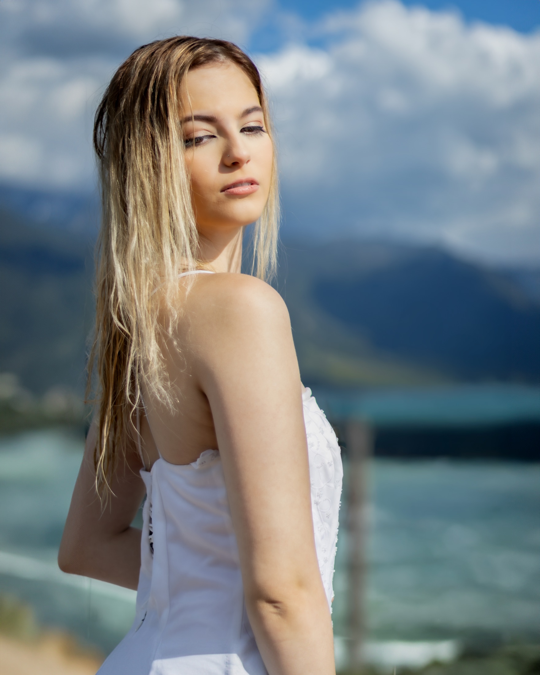 Novia de perfil con el cabello al viento y vista a las montañas