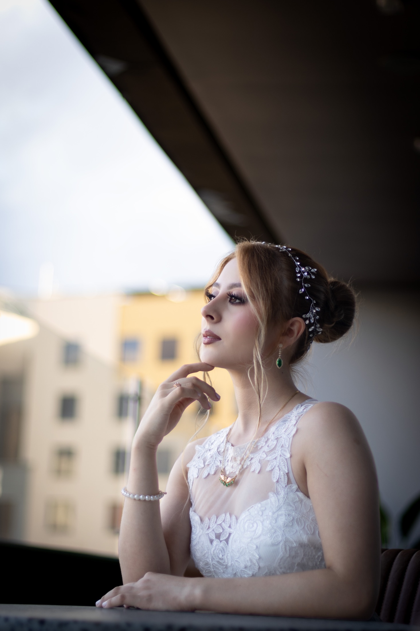 Novia sentada en una terraza con vista a los edificios de la ciudad