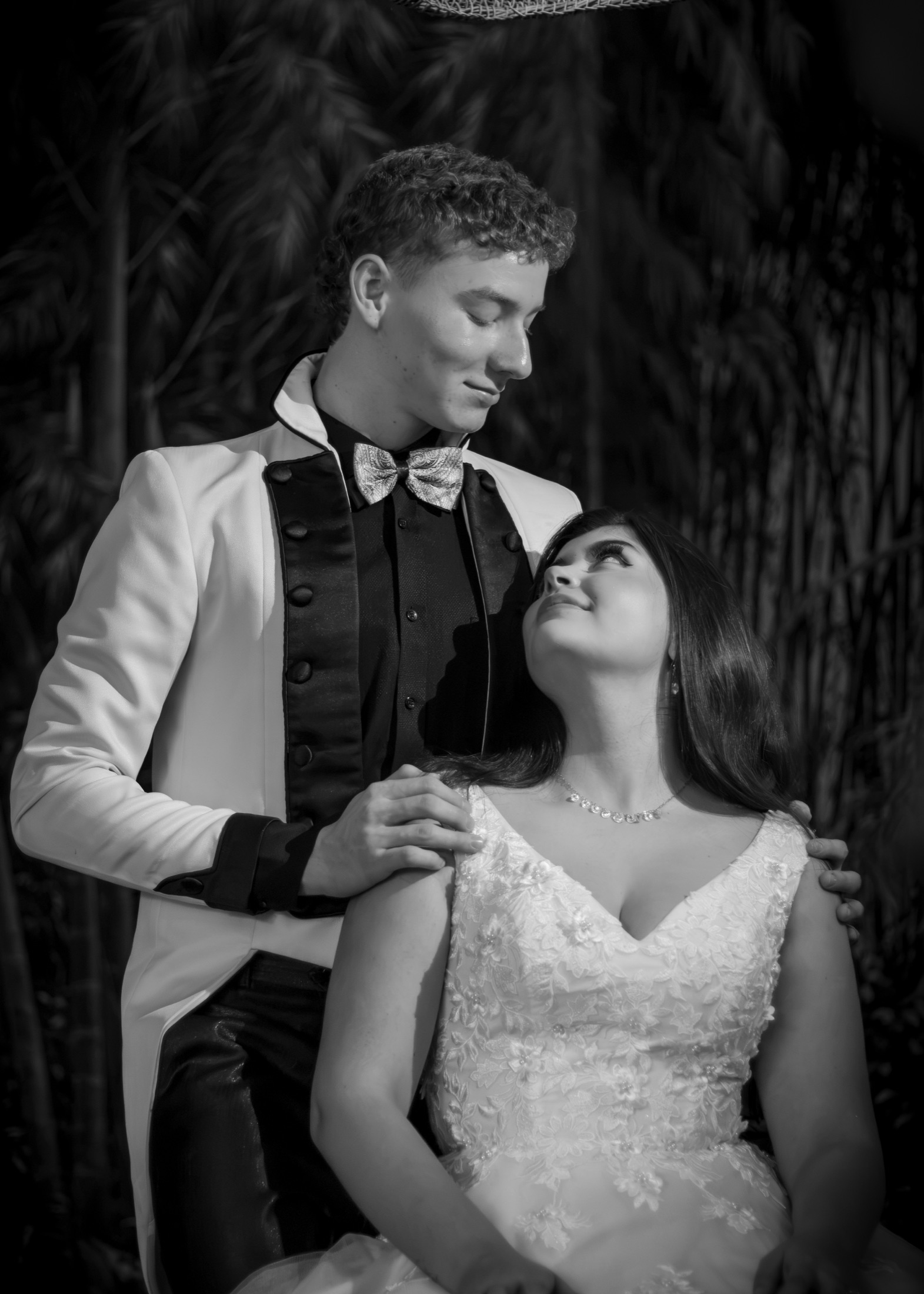 Pareja de novios mirándose fijamente en blanco y negro, ella con esmoquin blanco y negro
