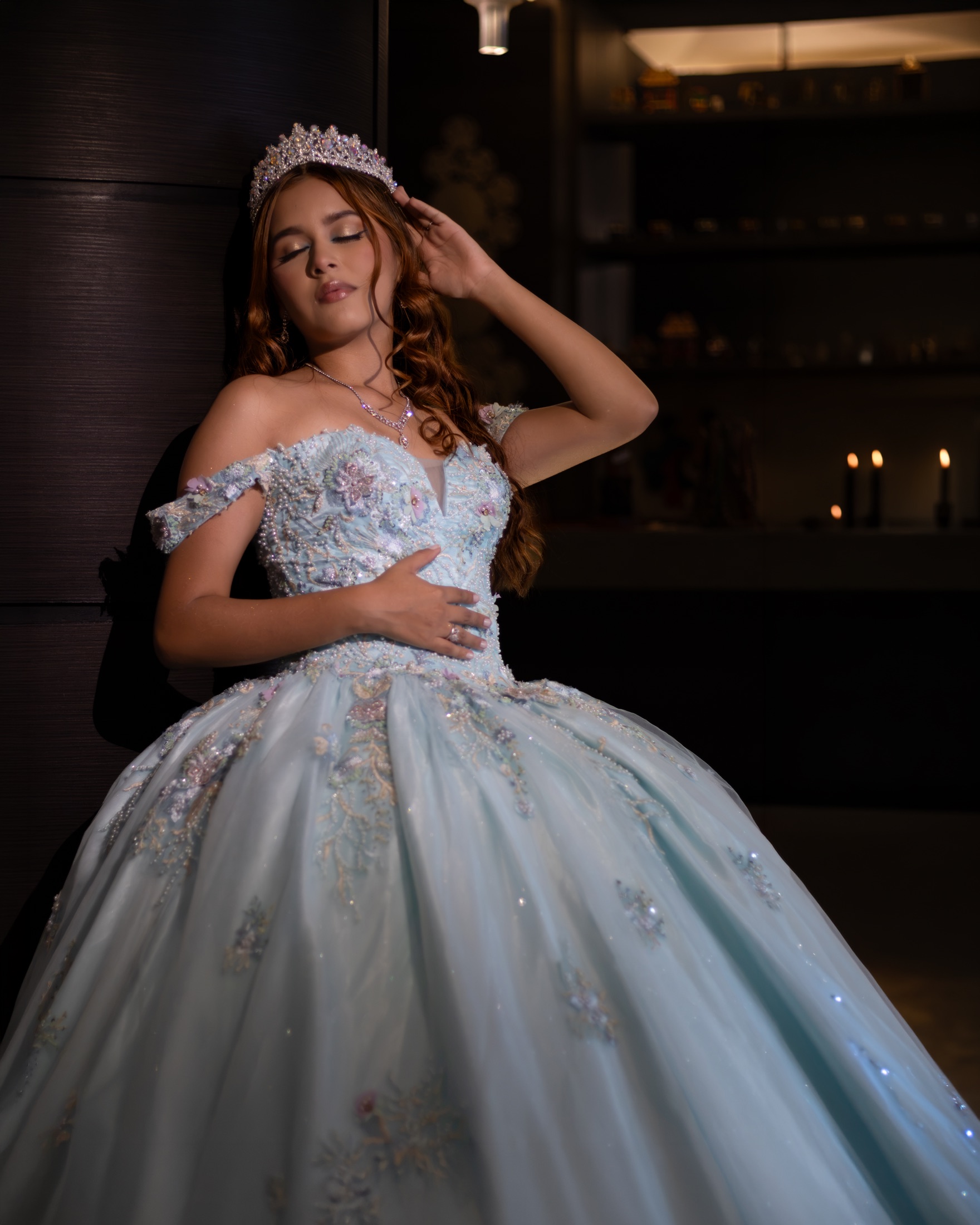 Quinceañera con vestido azul claro y las manos en la cintura